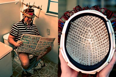 OverMachoGrande sitting on a toilet, reading the paper, and using his very first laser helmet!